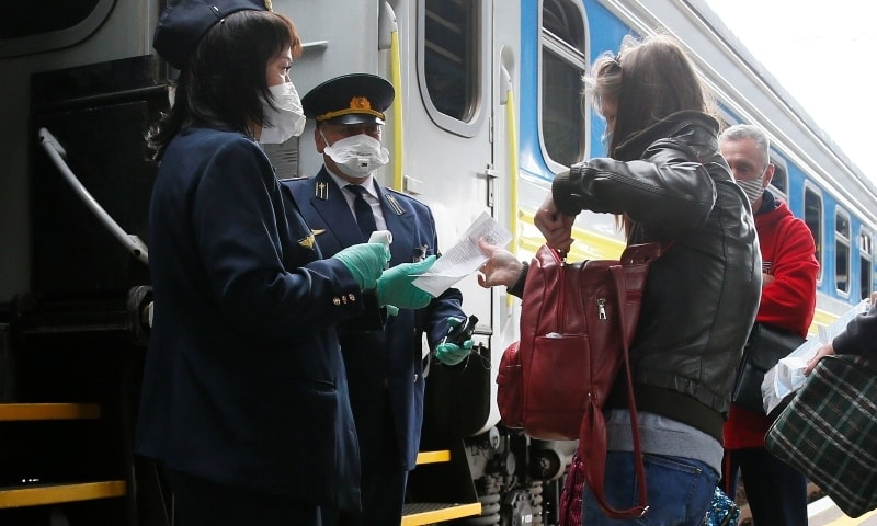 Conductors check tickets of passengers before departure at the central railway station in Kiev on June 1. — Reuters