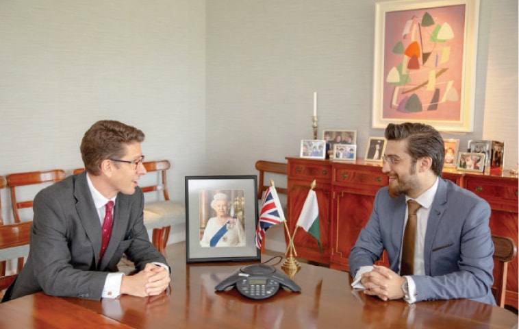British High Commissioner Dr Christian Turner meets Syed Hassaan Irfan, one of the recipients of Commonwealth Award, on Saturday. — Dawn
