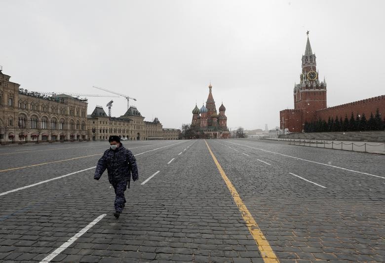 A law enforcement officer wearing a protective face mask walks across Red Square in Moscow, Russia. — Reuters/File