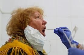 A healthcare worker takes a swab from a woman during testing for Covid-19 and antibodies at a clinic in Moscow, Russia. — Reuters