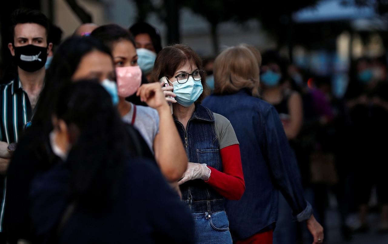 People wearing face masks queue to enter a reopened Primark store in Madrid as Spain eases lockdown restrictions. — Reuters
