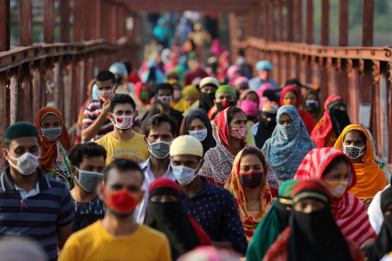 Garment workers return from a workplace in Dhaka, Bangladesh. &mdash; Reuters