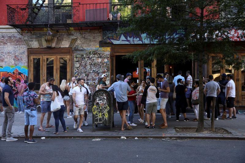People drink outside a bar during the reopening phase following Covid-19 outbreak in the East Village neighbourhood of New York City, US, June 13. &mdash; Reuters