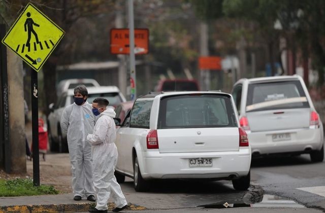 Mortuary workers wait outside the San Jose public hospital morgue in Santiago, Chile. &mdash; Reuters
