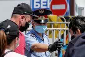 A police officer wearing a protective mask directs local residents as they walk through a checkpoint in Almaty, Kazakhstan, May 11. &mdash; Reuters