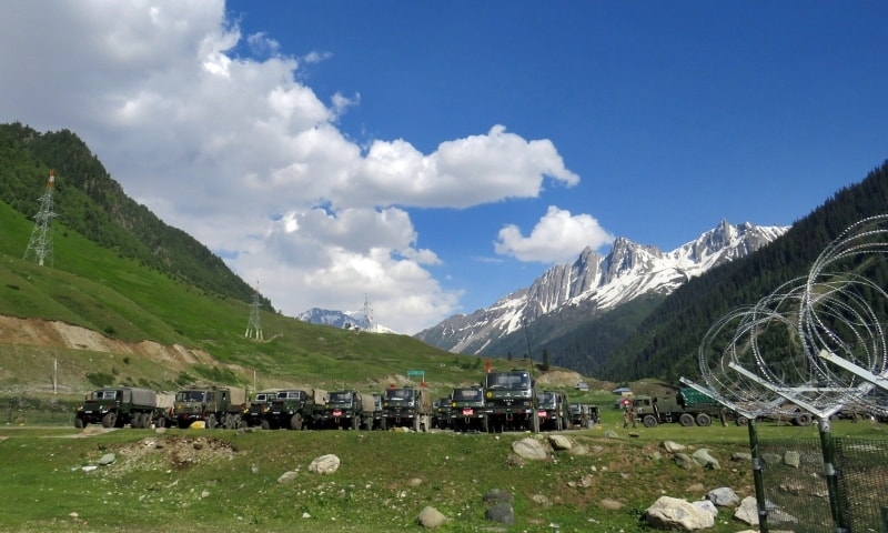 Indian army soldiers walk past their parked trucks at a makeshift transit camp before heading to Ladakh on June 16.   — Reuters