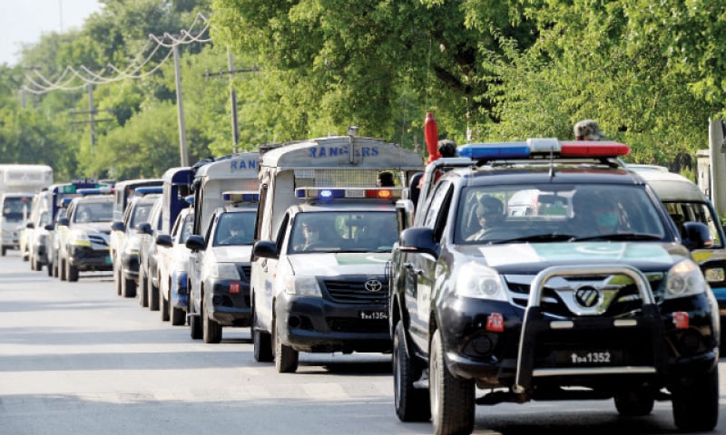 Security personnel pass through I-8 of Islamabad during a flag march on Wednesday. &mdash; Photo by Mohammad Asim
