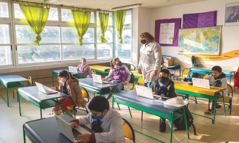 MONTEVIDEO (Uruguay): Students wearing protective face masks attend their class in a school.&mdash;AP