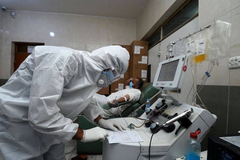 A phlebotomist draws blood plasma from a recovered Covid-19 patient in Iraq's southern city of Nasiriyah on June 24. &mdash; AFP
