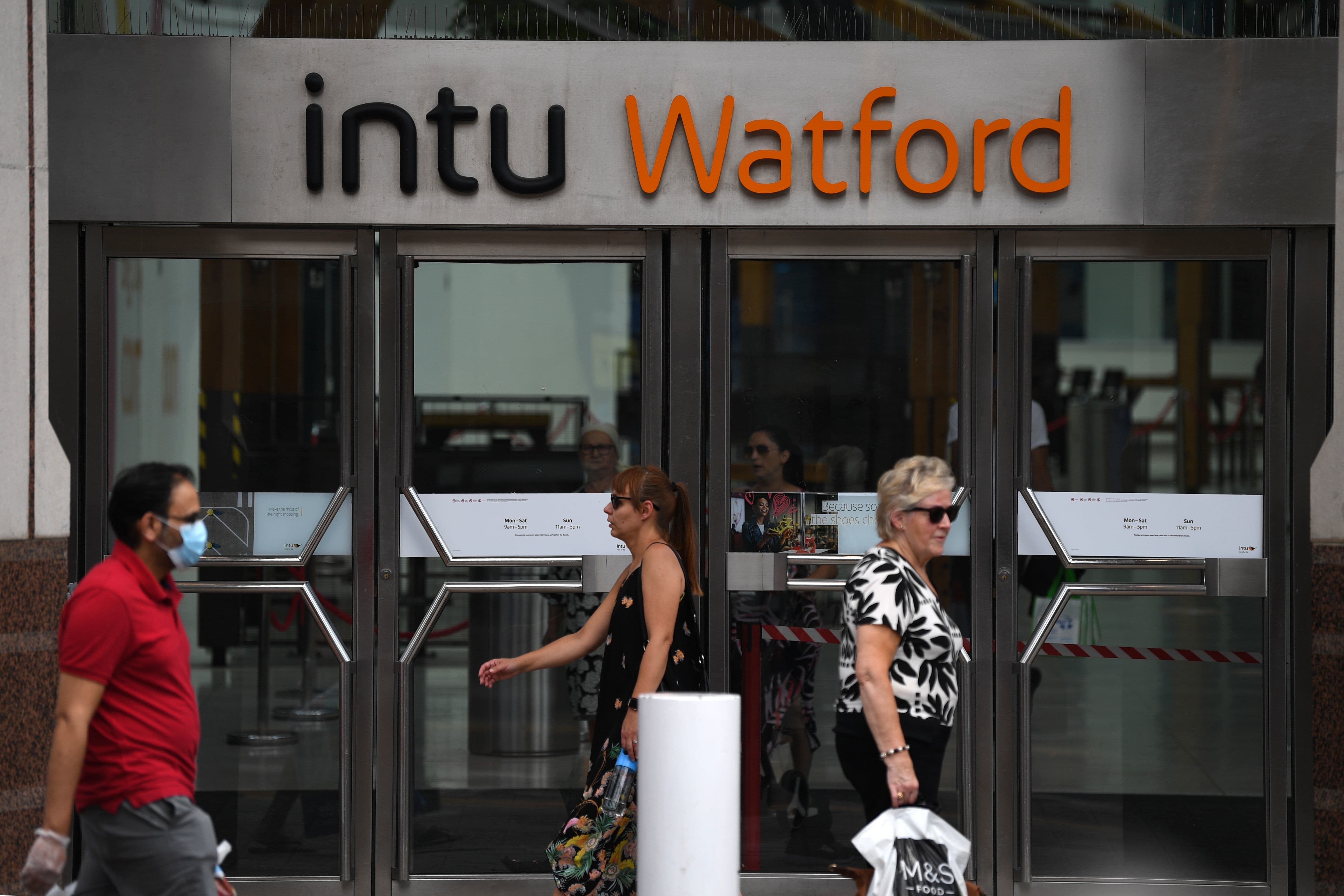 Shoppers walk outside the Intu Watford Shopping Centre in London, on June 26. — AFP