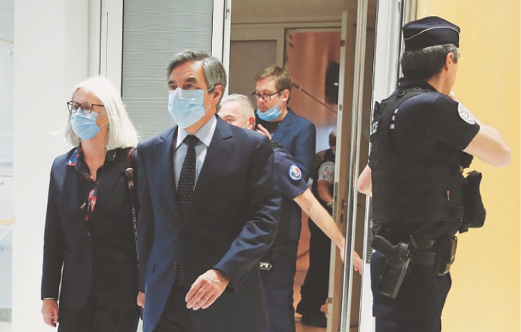 Former French prime minister Francois Fillon and his wife Penelope leave following the verdict in their trial over a fake job scandal at the courthouse in Paris on Monday.—Reuters