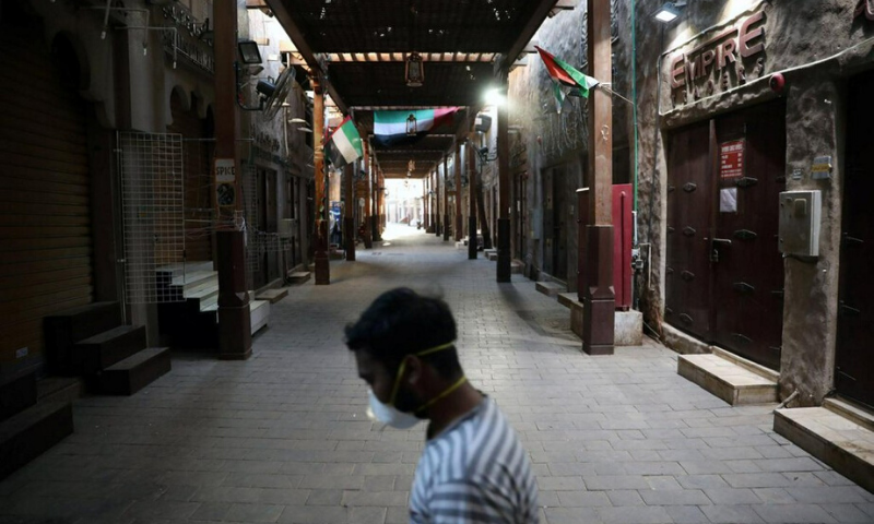 A man wearing a protective face mask walks through the deserted Barajeel Souq, following the outbreak of the coronavirus disease, in old Dubai, United Arab Emirates in March. &mdash; Reuters