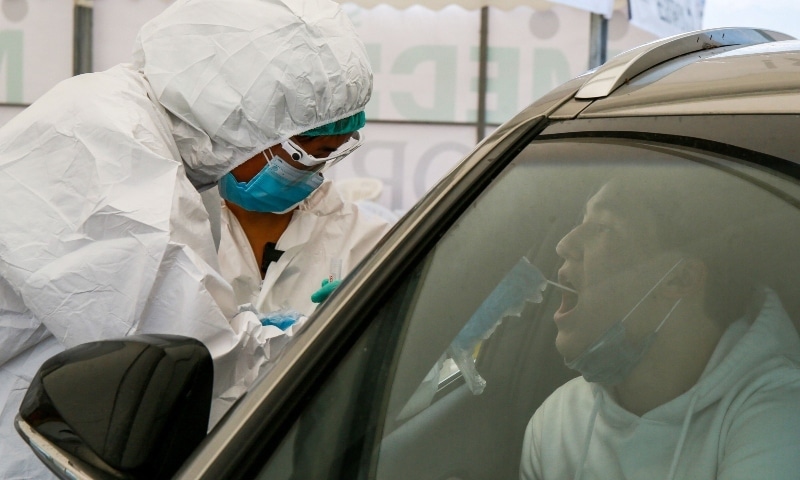 A healthcare worker gives a Covid-19 test to a medical staff near Halyk Arena in Almaty on July 5. &mdash; AFP