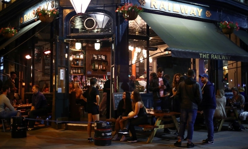 A general view shows people at a bar in Clapham, after the reopening of commercial activities following the outbreak of the coronavirus disease, in London. &mdash; Reuters