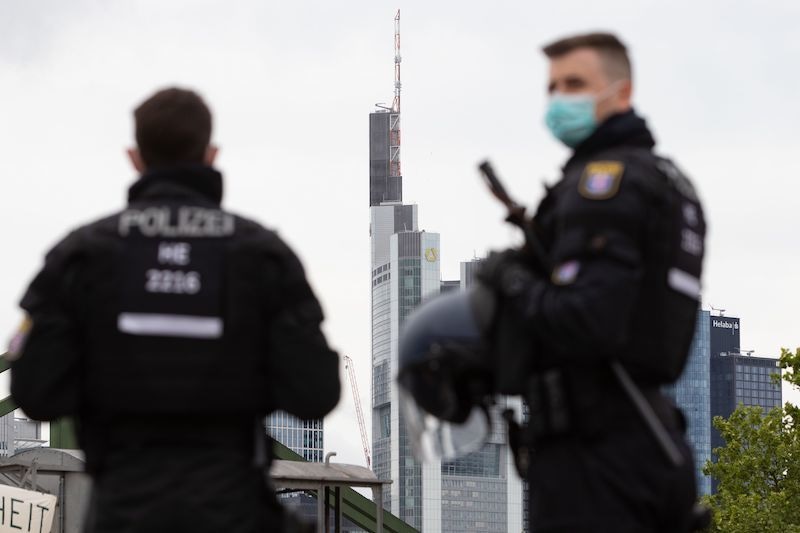 In this file photo taken on May 23, 2020 police officers wearing face masks are pictured in front of Commerzbank and Helaba headquarters during a rally against restrictions in place to limit the spread of the new coronavirus pandemic in Frankfurt am Main, western Germany. Thirty-nine people were detained after police were attacked with "a hail of bottles" at an open-air party in central Frankfurt attended by thousands of youngsters, police in the German city said on July 19, 2020. — AFP