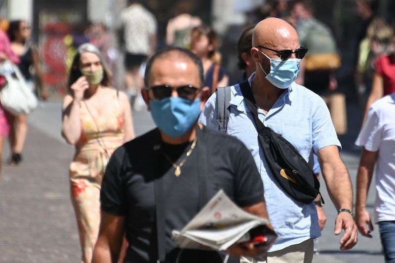 People wearing protective masks walk on a street in Lille, northern France, on July 30, 2020, as The Nord Prefecture announced, the reinforcement of the health measures at a local level to attempt to halt the rising cases of coronavirus Covid-19, which have been seen in the region during the past two weeks. - In a discussion between the French Health Minister, The Nord Prefet and Nord Regional Health Agency director (ARS) on July 29, the possibility of making the wearing of protective masks compulsory outside "due to the proximity with Belgium" was spoken of in an effort to halt the rise of co