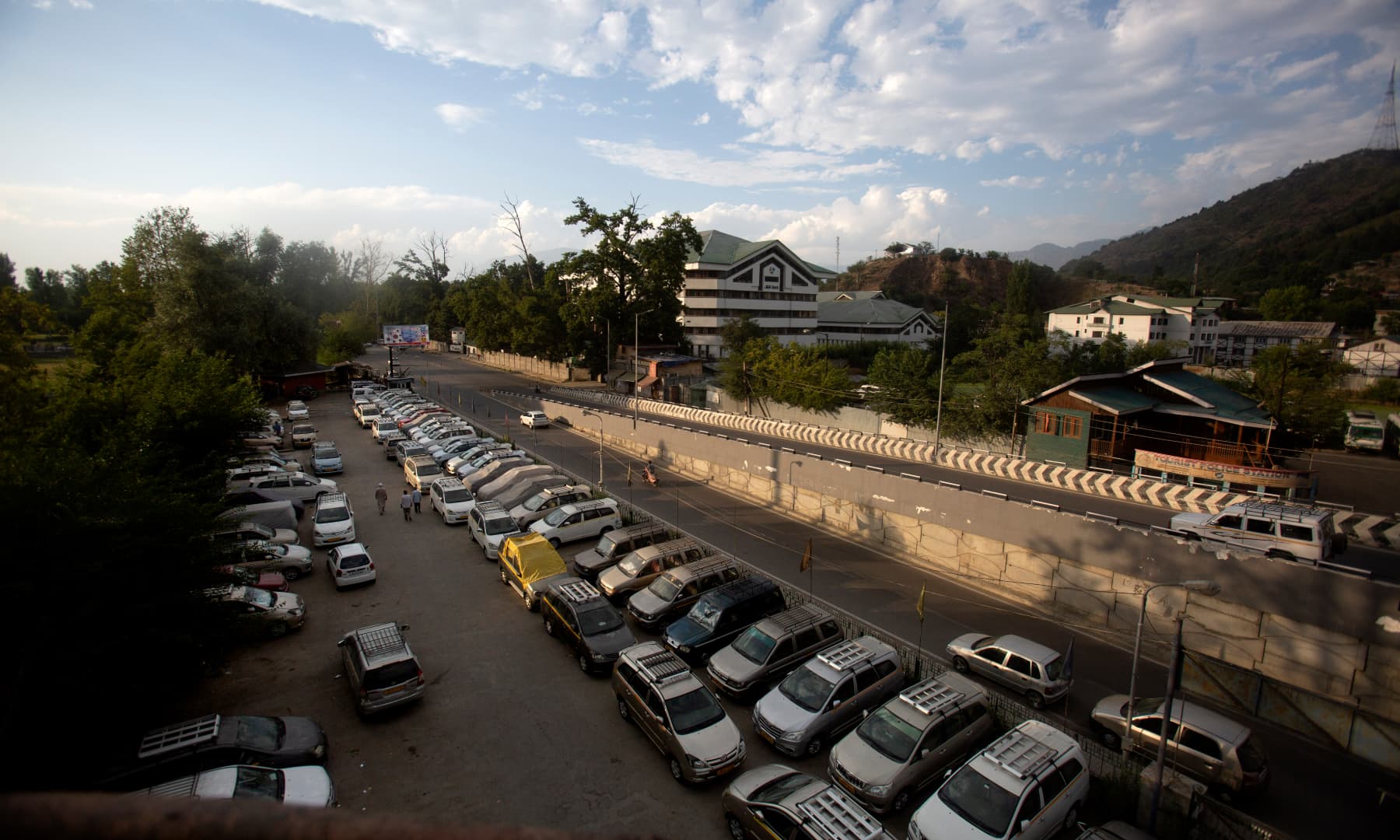 Kashmiri taxi drivers walk near their parked vehicles inside a deserted tourist taxi stand during lockdown in Srinagar, July 20. — AP