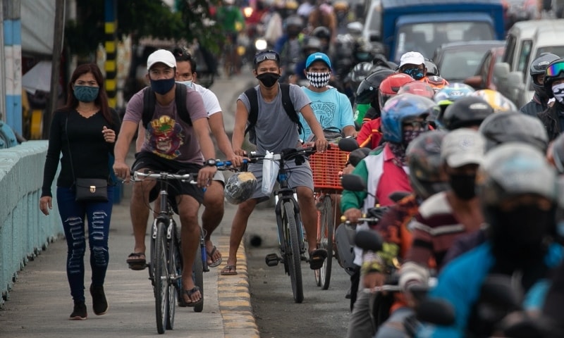 Cyclists bike on a sidewalk as traffic builds up at a checkpoint on the first day of the government's re-implementation of a stricter lockdown in Marikina City on August 4. — Reuters