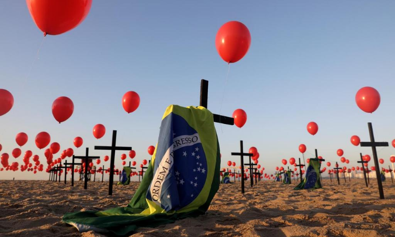 Crosses, balloons and Brazilian flags are seen at Copacabana beach, placed by members of the NGO Rio de Paz in tribute to the 100,000 victims of the coronavirus  in the country, in Rio de Janeiro, Brazil on Saturday. &mdash; Reuters