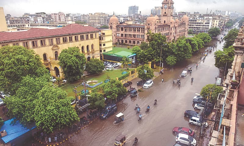 VEHICLES wade through rainwater on MA Jinnah Road on Saturday in front of the KMC head office.—Fahim Siddiqi/White Star