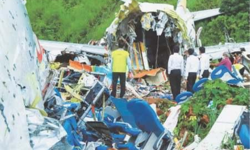 KARIPUR (India): Officials inspecting on Saturday the wreckage of the plane that crashed after skidding off the airport near here. — AFP