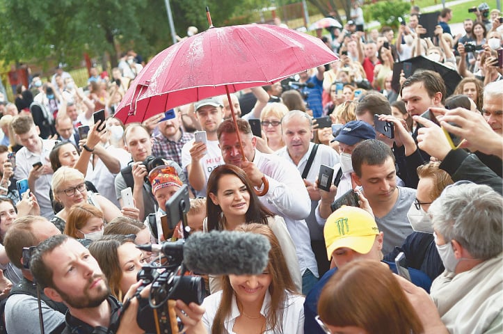 MINSK: Voters and journalists surround joint opposition candidate Svetlana Tikhanovskaya (centre) as she arrives to cast her ballot at a polling station on Sunday.—AFP