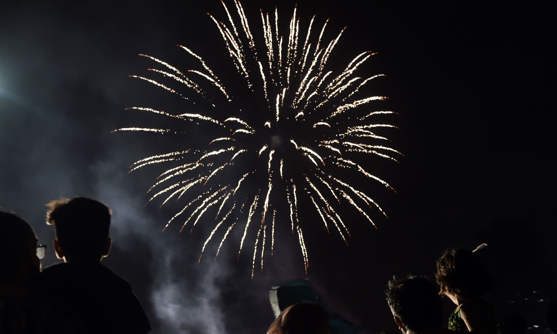 People watch fireworks on a street during Independence Day celebrations in Karachi on August 14. — AFP