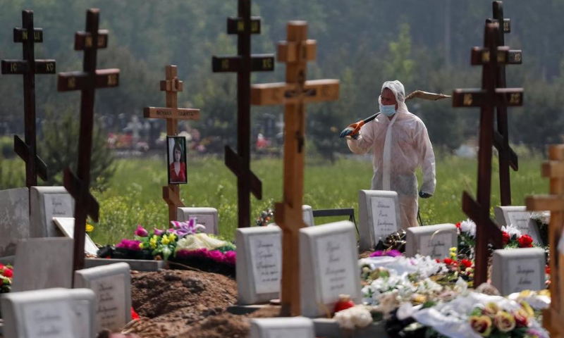 A grave digger wearing personal protective equipment (PPE) walks after burying a person, who presumably died of the coronavirus in the special purpose section of a graveyard on the outskirts of Saint Petersburg, Russia. &mdash; Reuters/File
