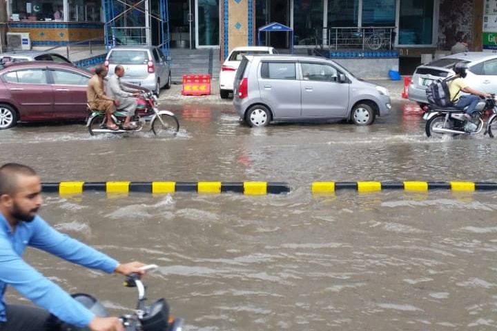 Commuters pass through an inundated road near Lahore's Defence Boulevard after heavy rainfall lashed the city through the night into Thursday morning. —  Dawn.com