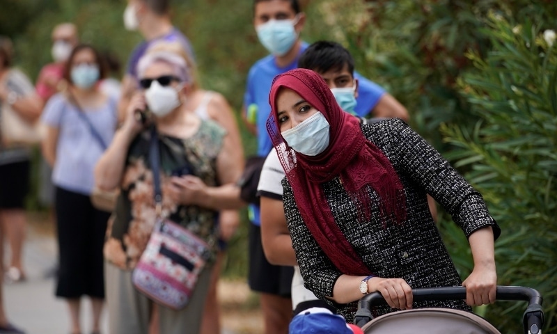 People queue to make PCR test outside at Federica Montseny primary health care centre in Madrid on August 20. — Reuters