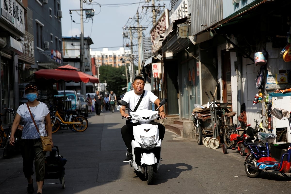 A man without wearing a face mask rides on a scooter at a hutong, after Beijing Centre for Disease Prevention and Control announced that wearing face masks are no longer mandatory outdoor in Beijing, following the coronavirus disease (Covid-19) outbreak, China, August 21, 2020. &ndash; Reuters