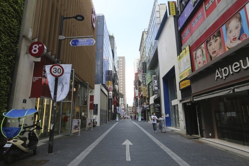 A couple wearing face masks to help protect against the spread of the coronavirus walks along on a nearly empty shopping street in Seoul, South Korea, Sunday, Aug. 23, 2020. &ndash; AP