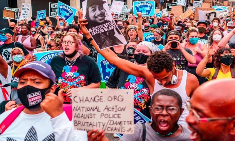 Protesters march near the Minneapolis 1st Police precinct during a demonstration against police brutality and racism on August 24, 2020 in Minneapolis, Minnesota. — AFP