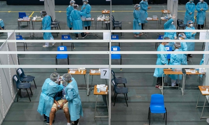 Medical workers collect samples at a makeshift testing site for Covid-19 infections at the Queen Elizabeth Stadium in Hong Kong on September 1. — AFP