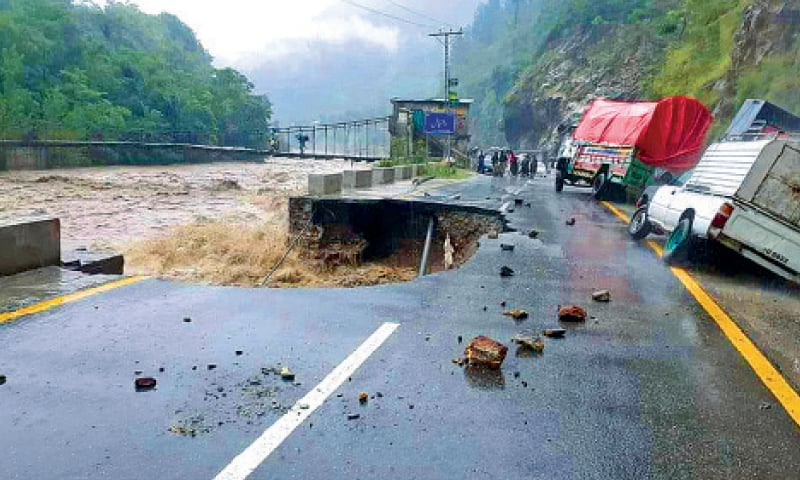 A portion of Bisham-Swat Road washed away by the swollen river in Shangla on Tuesday. — Dawn