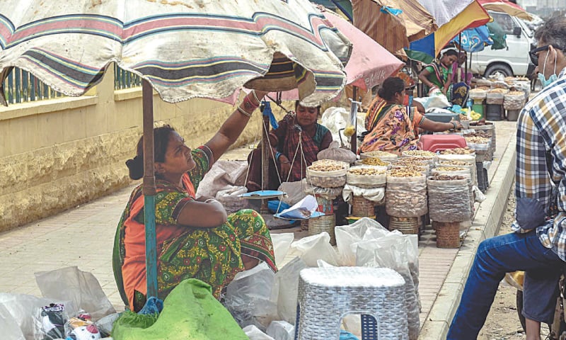 WOMEN sell dried fruit at the Empress Market.—White Star