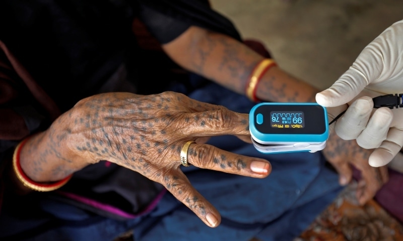 A healthcare worker puts a pulse oximeter on a woman's finger to check her oxygen level during a door-to-door survey in Moriya village on the outskirts of Ahmedabad on September 14. — Reuters A healthcare worker puts a pulse oximeter on a woman's finger to check her oxygen level during a door-to-door survey in Moriya village on the outskirts of Ahmedabad on September 14. — Reuters