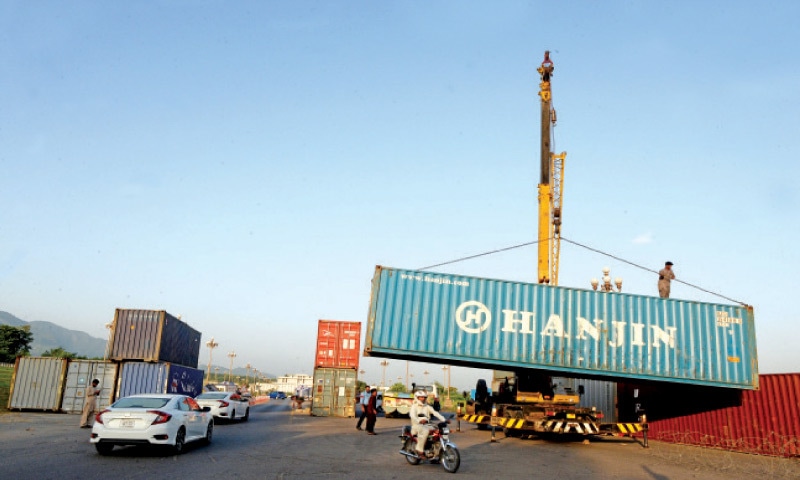 The district administration places containers at D-Chowk in Islamabad on Wednesday, ahead of the Muttahida Sunni Council procession on Thursday. — Photo by Mohammad Asim