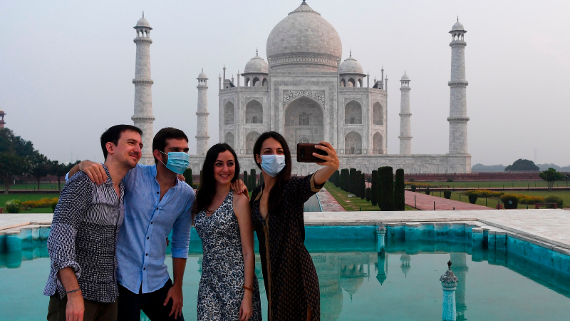 Tourists have their pictures taken at the Taj Mahal in Agra on Sept 21. &mdash; AFP