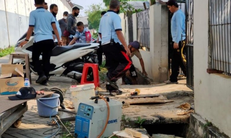 Officers check the culvert used by a Chinese prisoner to escape in Tangerang, Banten on September 18. — AFP