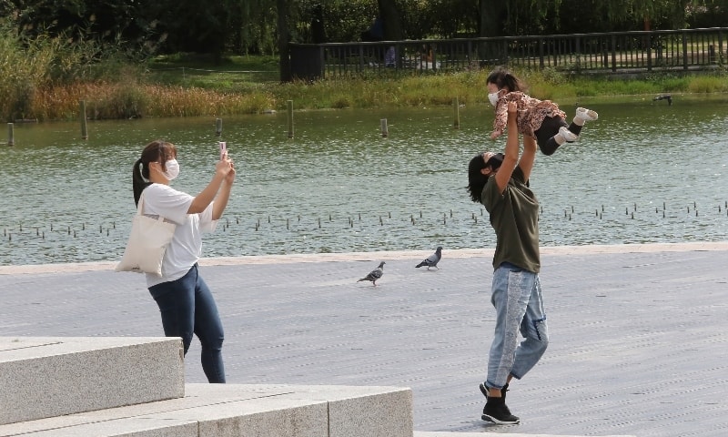 A family wearing face masks to help protect against the spread of the coronavirus enjoy themselves at a park in Seoul on September 23. — AP
