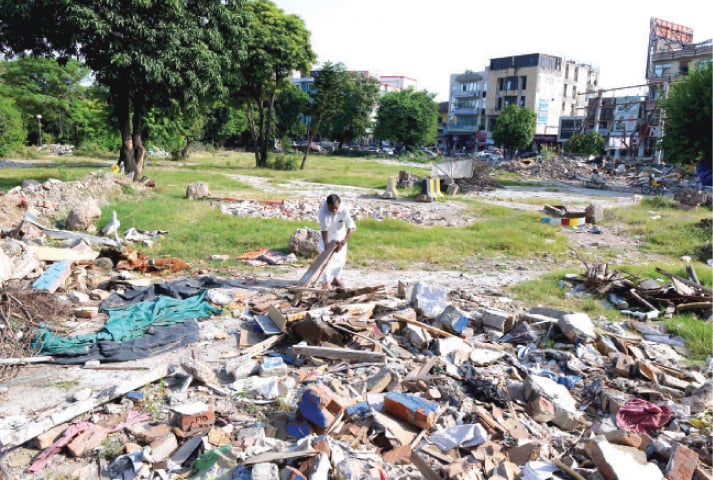 A ragpicker sifts through debris at a park in Rawalpindi’s Commercial Market. The park was demolished to make way for a car park. — White Star