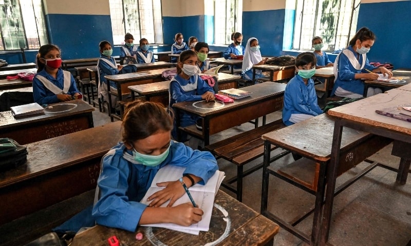 Children wearing facemasks attend a class at a school in Lahore on September 30. &mdash; AFP