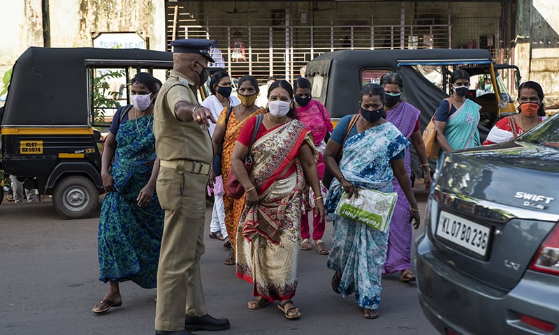 A policeman asks workers to leave the area after the Cochin Special Economic Zone that houses several industrial units was closed as part of Covid-19 containment measures in Kerala on October 1. &mdash; AP