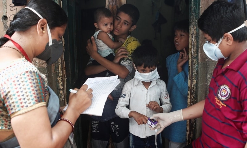 Community health volunteers check the pulse of a resident during a check-up campaign for the coronavirus in Mumbai on October 3. &mdash; Reuters