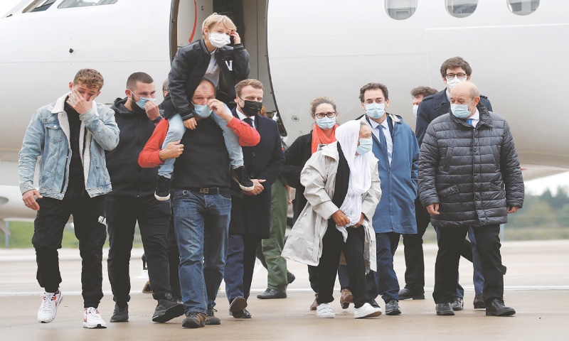 Paris: French Foreign Affairs Minister Jean-Yves Le Drian accompanies Sophie Petronin (in white coat) upon her arrival at a military airport on Friday.—Reuters Paris: French Foreign Affairs Minister Jean-Yves Le Drian accompanies Sophie Petronin (in white coat) upon her arrival at a military airport on Friday.—Reuters
