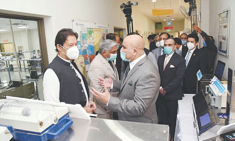 ISLAMABAD: Prime Minister Imran Khan being briefed during his visit to the N-ovative Health Technologies Facility at NUST on Friday.—PPI