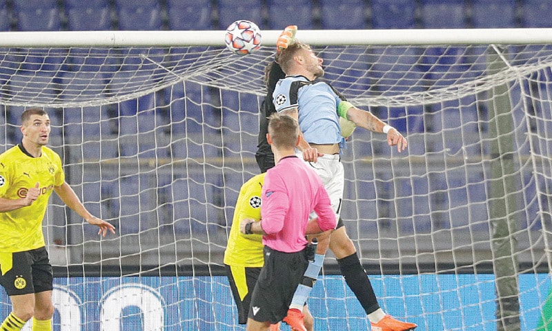 ROME: Borrusia Dortmund goalkeeper Marwin Hitz jumps for the ball with Lazio’s Ciro Immobile at the Olympic Stadium.—AP