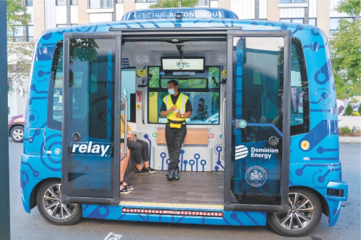 FAIRFAX (Virginia, US): Jason Peres (centre) explains to riders how Relay, an electric autonomous vehicle, works. &mdash;AP