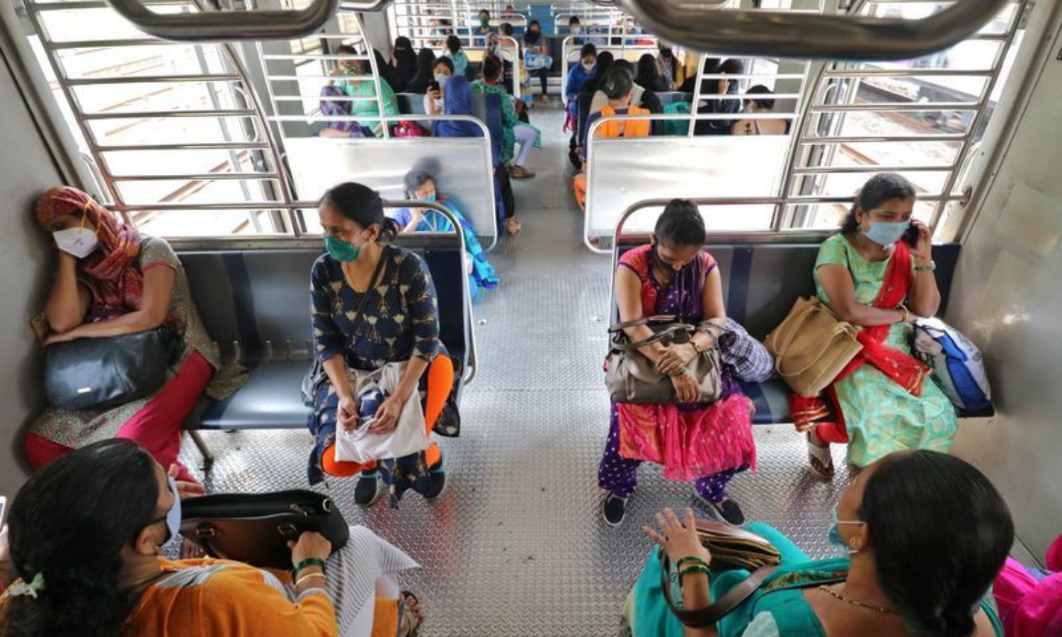 Women wearing protective face masks commute in a suburban train after authorities resumed the train services for women passengers during non-peak hours, amidst the coronavirus outbreak, in Mumbai, India. &mdash; Reuters